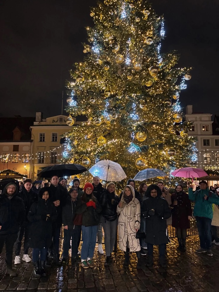 Stay Larsen residents under umbrellas in front of the Christmas tree on Tallinn Town Hall Square