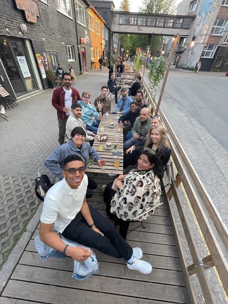 Residents around a long outdoor table with drinks on a summer evening